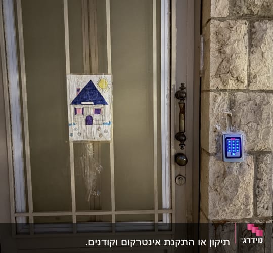 דלת עם ציור ומערכת אינטרקום מותקנת בצד